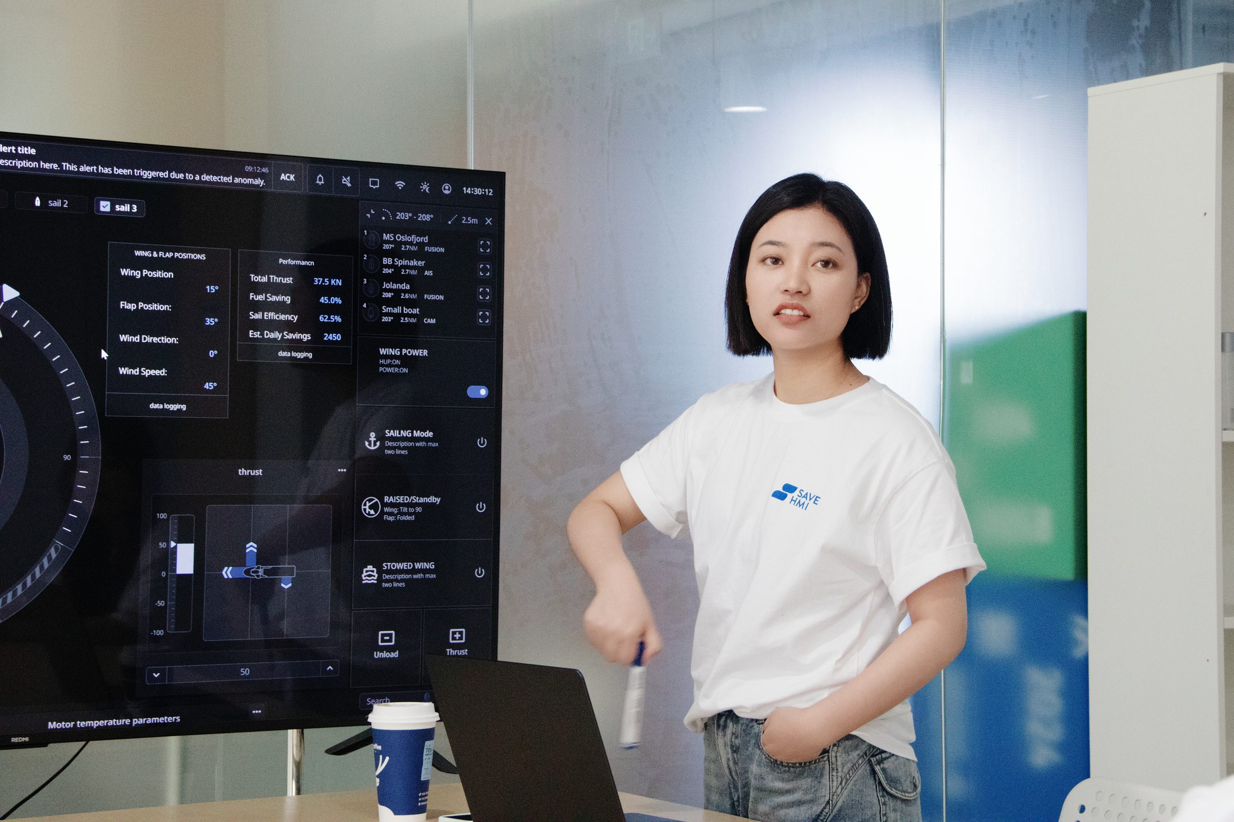 设计师在大屏前讲解一套船用设备 HMI 的设计方案