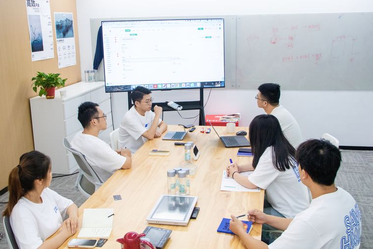 团队围着长桌开项目会